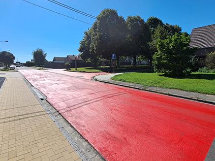 Résine Rollplast rouge appliquée sur la route